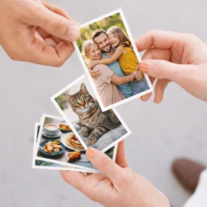 Manos sosteniendo varias fotos de 9x13 cm, con imágenes de familia, un gato, comida y un paisaje de viaje
