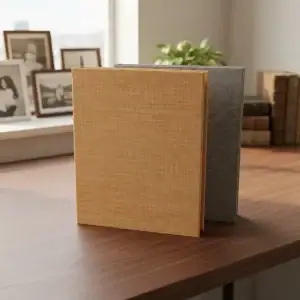 Álbumes de fotos 15x21 con cubiertas de lino en tonos marrón claro y gris en mesa de madera.