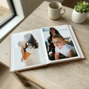 Álbumes de fotos 15x21 con cubiertas de lino en tonos marrón claro y gris en mesa de madera.
