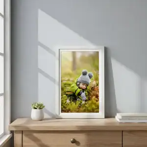 Cuadro de 40x60 cm con paspartú, apoyado en mesa de madera al lado de una ventana