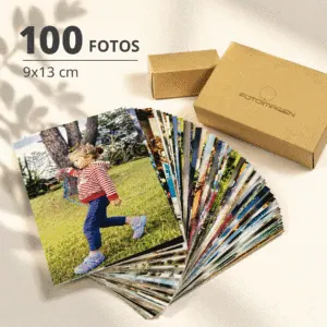 Pack de 100 fotos 9x13 en abanico sobre una mesa con una cajita de carton craft de Fotoimagen al lado