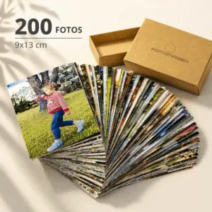 Pack de 200 fotos 9x13 en abanico sobre una mesa con una cajita de carton craft de Fotoimagen al lado