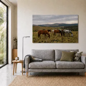 Fotografia de 90x60 en Papel Fotográfico de impresión en Plotter pegada en Sintra (PVC de 3mm) de unos caballos. Dispuesta en una pared sobre un sillon de dos plazas en una casa moderna.